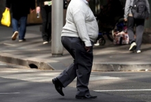 Pedestre com sobrepeso atravessa rua